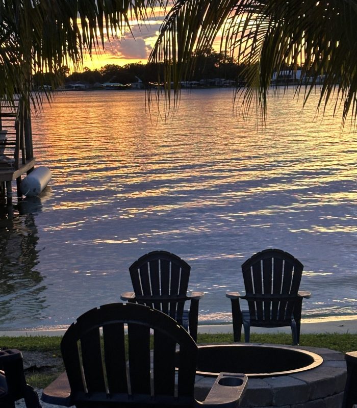 Sunset View of the Fire Pit and Seating Overlooking the Lake and Dock