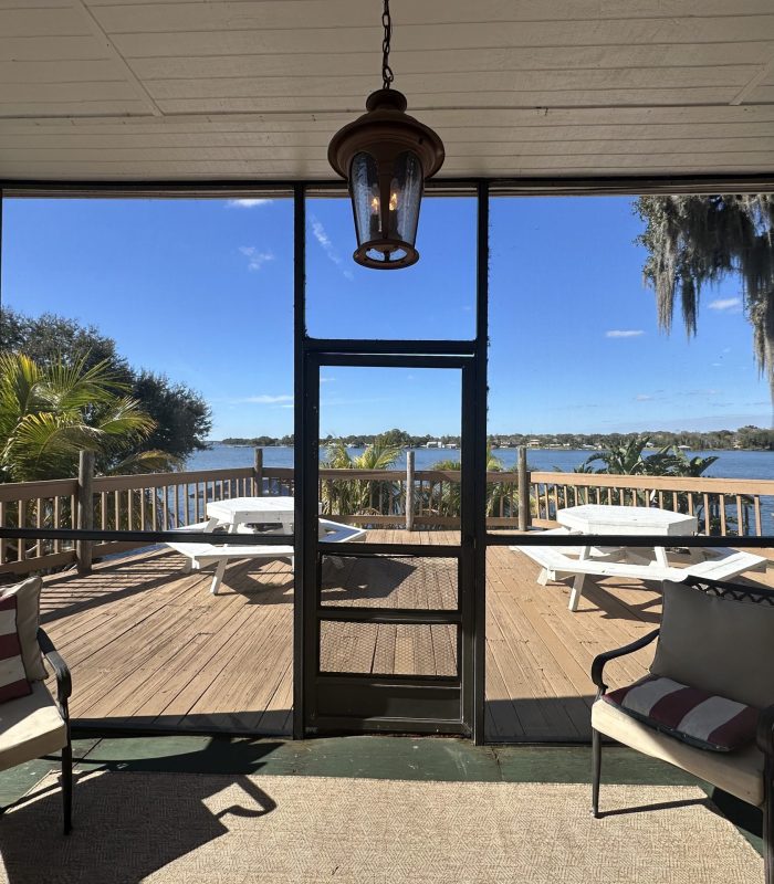 Photo of the Screened-In Patio With the Deck and Hexagonal Picnic Tables in the Background