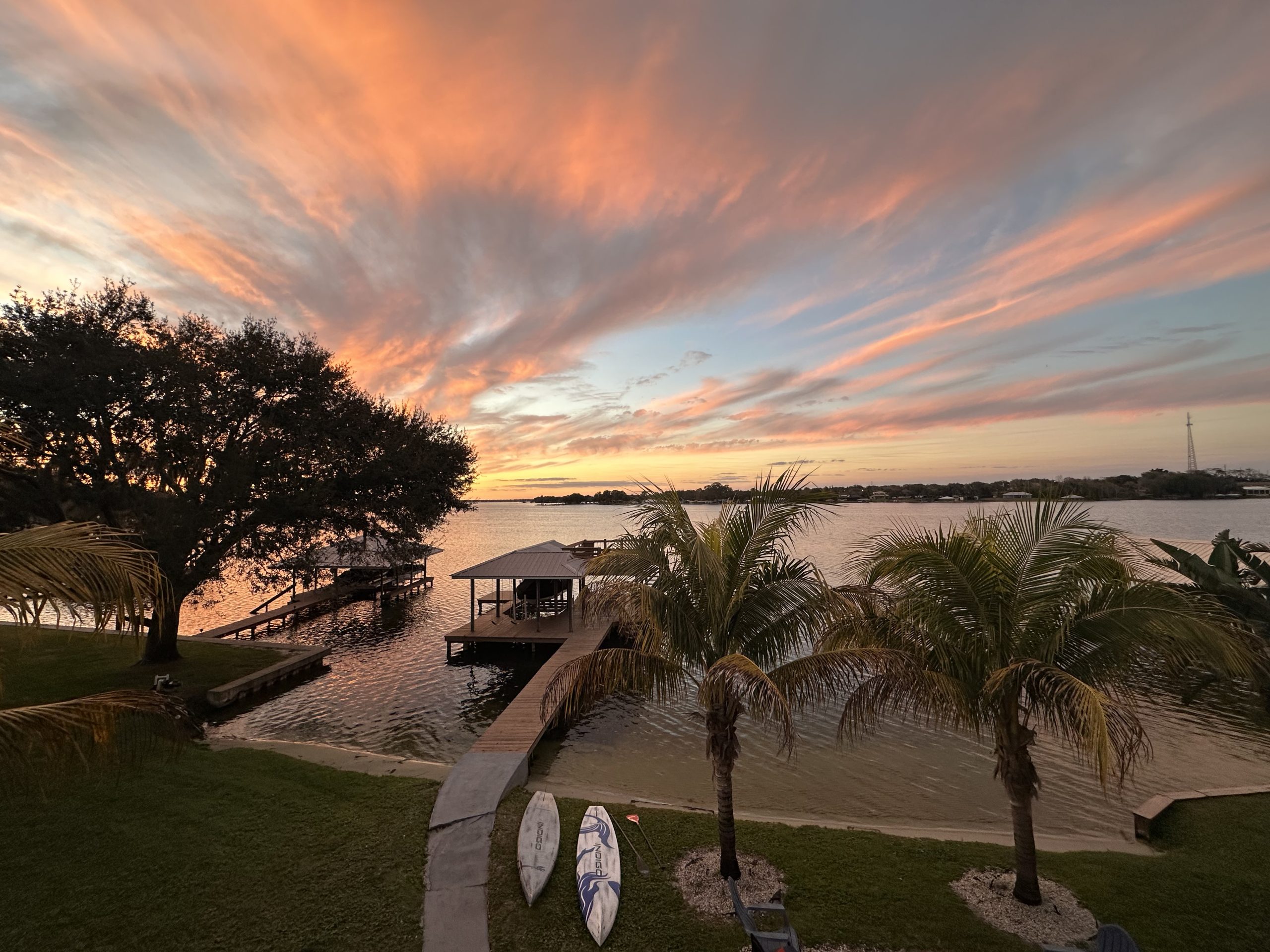 Photo of Dock During Sunset with Pink and Grey Clouds Stretching Out From the Horizon